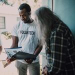 Volunteers visit a home to provide community support and discuss documents.